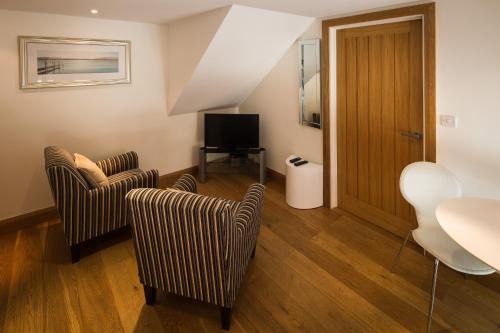 a living room with two chairs and a television at Ashbrook Lets Apartments in Blewbury