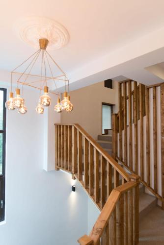 a staircase in a house with a chandelier at Vila PANORAMIC Busteni in Buşteni