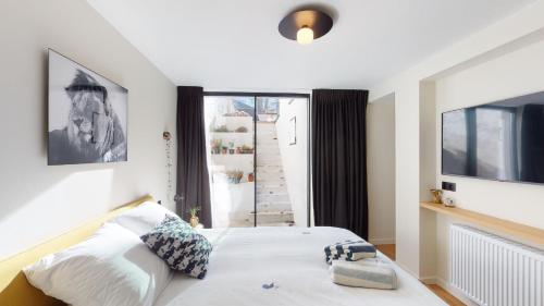a bedroom with a bed and a large window at Suite lumineuse à Saint-Gilles in Brussels