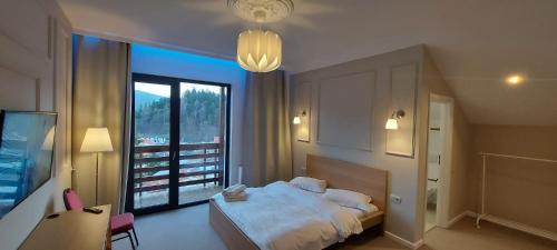 a bedroom with a bed and a large window at Vila PANORAMIC Busteni in Buşteni