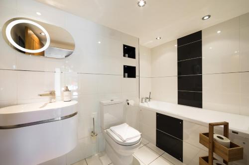 a white bathroom with a toilet and a sink at Ashbrook Lets Apartments in Blewbury