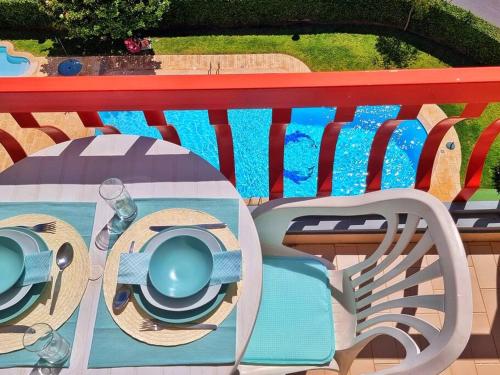 a red bench with a table with plates and glasses at Tivoli Apt8 with Pool&Garage in Vilamoura