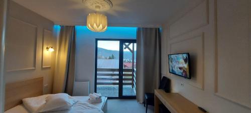 a hotel room with a bed and a view of a balcony at Vila PANORAMIC Busteni in Buşteni