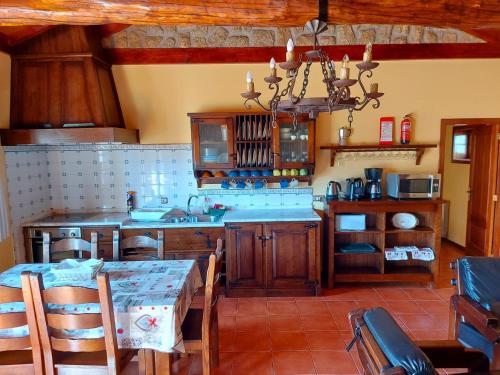 a kitchen with a dining table and a chandelier at Casa das Vessadas in Celorico de Basto
