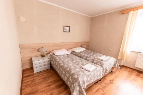 a bedroom with two beds and a wooden floor at Byczy Rog noclehy na hranici in Králíky