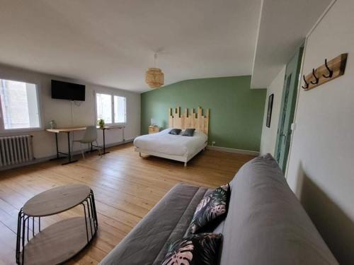uma sala de estar com um sofá e uma cama em La Maison des Martinettes em Étauliers