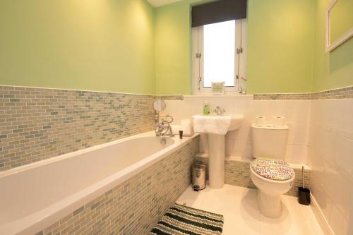 a bathroom with a tub and a toilet and a sink at PREMIER - Chapel Street Apartment in Cleland