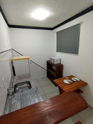 a small room with a sink and a table at Flat Schnneider, Hospedagem econômica, empresas, diárias in Taubaté