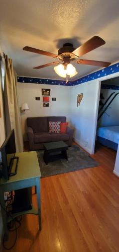 a living room with a couch and a ceiling fan at Hikers Cimarron Inn & RV Park in Cimarron