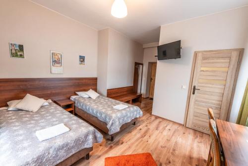 a hotel room with two beds and a television at Byczy Rog noclehy na hranici in Králíky