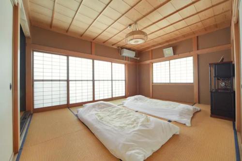 Kouya - Vacation STAY 70479v في تاكاياما: سريرين في غرفة كبيرة مع نوافذ