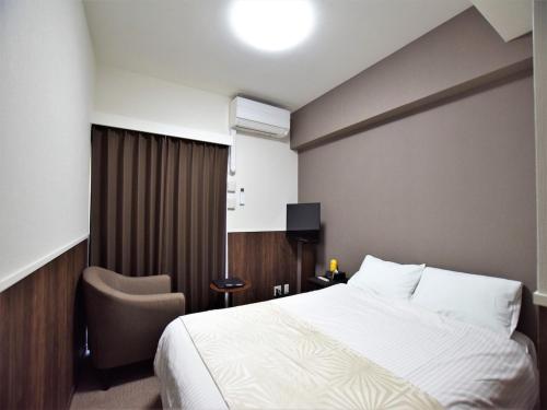 een hotelkamer met een bed en een stoel bij Land-Residential Hotel Fukuoka - Vacation STAY 81812v in Fukuoka