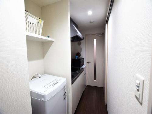 La petite salle de bains est pourvue d'un lavabo et d'un lave-linge. dans l'établissement Land-Residential Hotel Fukuoka - Vacation STAY 81843v, à Fukuoka