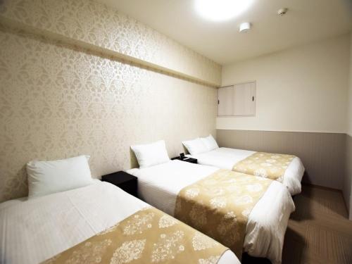 una habitación de hotel con 3 camas. en Land-Residential Hotel Fukuoka - Vacation STAY 81846v en Fukuoka