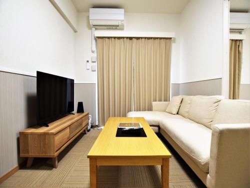 sala de estar con sofá y TV en Land-Residential Hotel Fukuoka - Vacation STAY 81846v en Fukuoka
