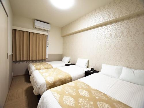 Habitación de hotel con 3 camas y ventana en Land-Residential Hotel Fukuoka - Vacation STAY 81846v, en Fukuoka