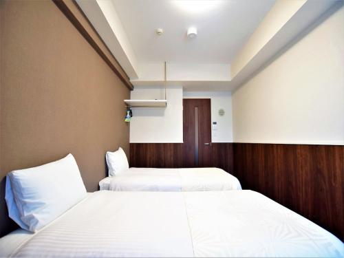 duas camas num quarto de hotel com lençóis brancos em Land-Residential Hotel Fukuoka - Vacation STAY 81857v em Fukuoka