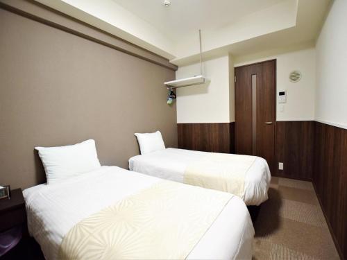um quarto de hotel com duas camas e uma porta em Land-Residential Hotel Fukuoka - Vacation STAY 81857v em Fukuoka