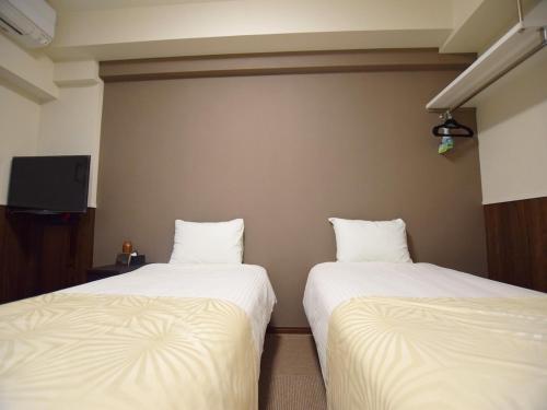 duas camas sentadas uma ao lado da outra num quarto em Land-Residential Hotel Fukuoka - Vacation STAY 81857v em Fukuoka