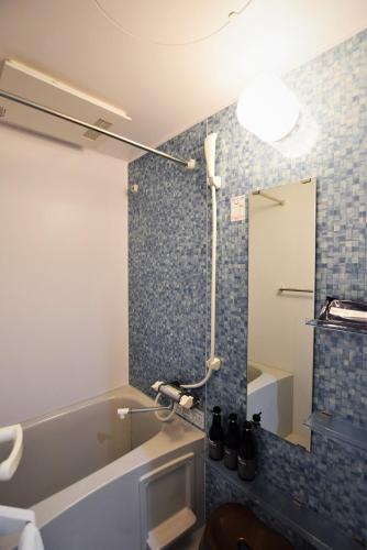 bagno con doccia e piastrelle blu sul muro di Land-Residential Hotel Fukuoka - Vacation STAY 81831v a Fukuoka