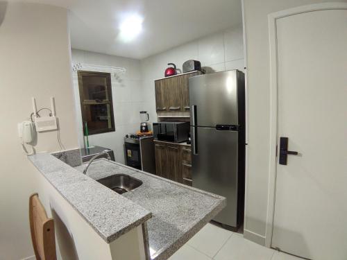 a kitchen with a stainless steel refrigerator at VG Sun Cumbuco Sea Breeze Vista Mar in Cumbuco