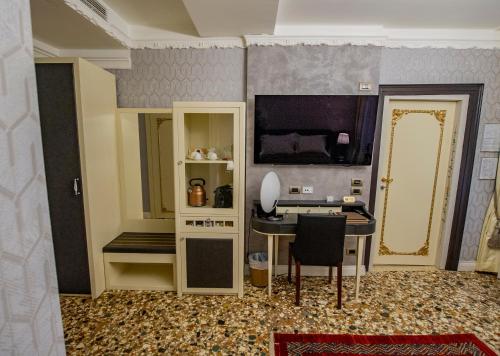 a room with a desk and a table and a tv at EGO' Boutique Hotel - The Silk Road in Venice
