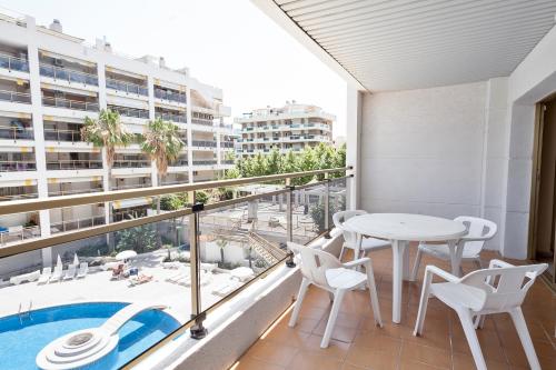 
a patio area with chairs, tables, and a balcony at Apartamentos Best Michelangelo in Salou
