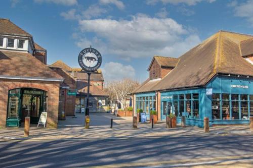 a town with a clock in the middle of a street at South Coast New Forest Holiday Home-4 Bed-Sleeps 8-Spacious-Parking-EV Dock-Large Garden-Playground-Great for Families-Groups-Professionals in Ringwood