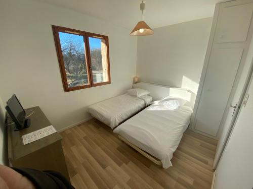 a small room with a bed and a window at Domaine L'Efferves'Sens in Chavanod