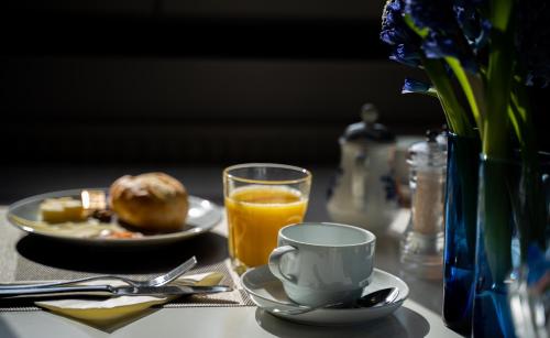 a table with a plate of food and a cup of orange juice at Hotel & Restaurant Tanne in Fischingen