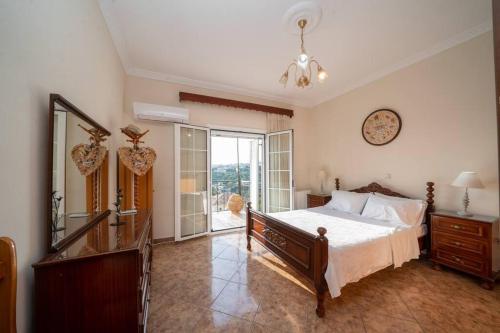 1 dormitorio con cama, espejo y ventana en Dimitris Luxury Apartment, en Kaligata