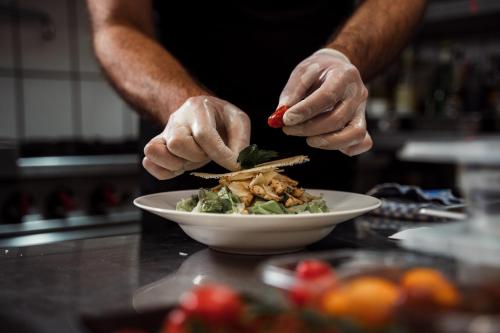 a person is preparing a salad in a bowl at Hotel & Restaurant Tanne in Fischingen