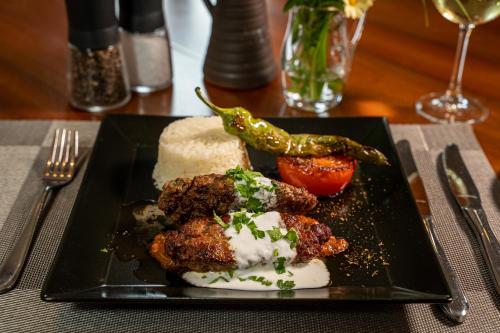 a black plate with food on a table at Hotel & Restaurant Tanne in Fischingen