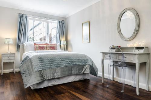 a bedroom with a bed and a desk and a mirror at Lovely 2 Bedroom Apartment Near South Bank in London