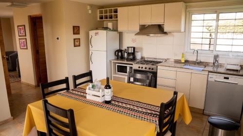 a kitchen with a table with a yellow table cloth at Magas de Drummond in Mayor Drumond