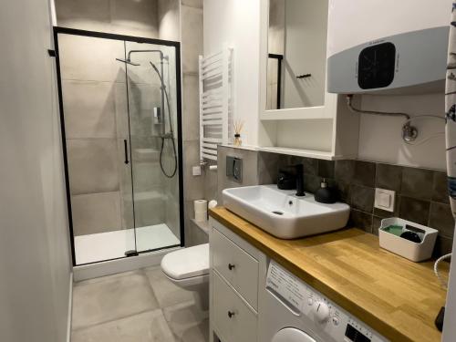 a white bathroom with a sink and a shower at URABN APARTMENTS Studio with garden No 2A Chorzów Katowice FREE PRIVATE PARKING in Chorzów