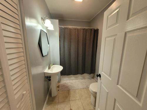 a white bathroom with a toilet and a sink at Modern Two Bedroom Home in Lakeland