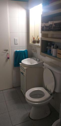 a bathroom with a white toilet and a sink at Habitación en casa in San Carlos de Bariloche