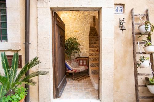 an open door to a courtyard with a chair in a building at SI-Moutique Le Case degli Avi barocche, con terrazza panoramica in Modica