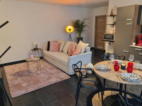 ein Wohnzimmer mit einem Sofa und 2 Tischen in der Unterkunft La suite de lati in Lüttich
