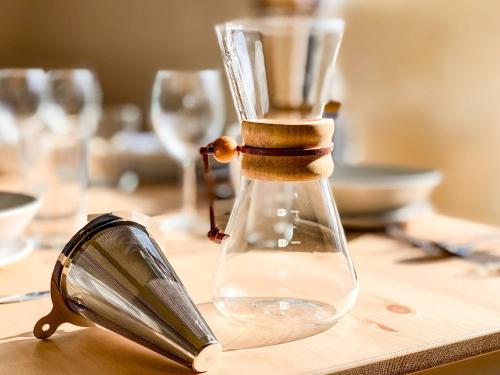 a glass bottle on a wooden table with a funnel at La Colina Retreat - Vacation STAY 10109v in Madarao Kogen