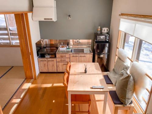 ein Wohnzimmer mit einem Tisch und einer Küche in der Unterkunft La Colina Retreat - Vacation STAY 07206v in Madarao Kogen