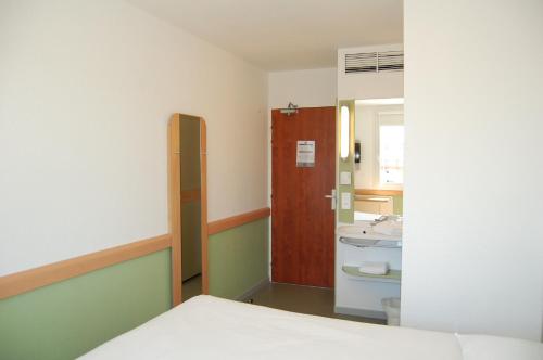 a room with a bathroom with a bed and a sink at Ibis Budget Marseille Vitrolles in Vitrolles