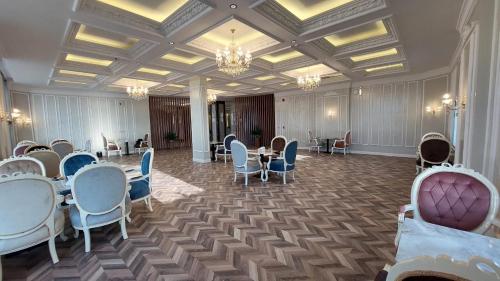 a large room with tables and chairs and chandeliers at فندق وريف الشرق in Sarat Abidah