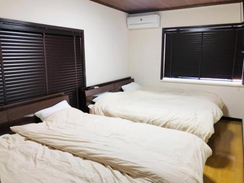 two beds in a room with a window at Maisonity Suizenji - Vacation STAY 10562v in Kumamoto
