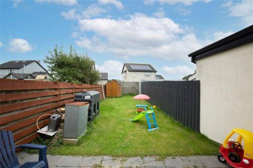 a yard with a fence and a playground with a play equipment at Ballyhack by the Sea in Arthurstown