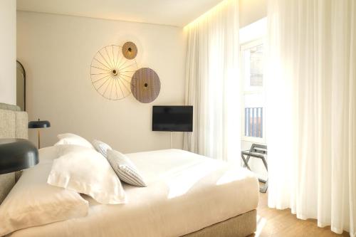 a bedroom with a bed and a clock on the wall at MouraSuites Hotel in Évora