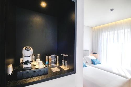 a room with a black accent wall and a coffee machine on a counter at MouraSuites Hotel in Évora