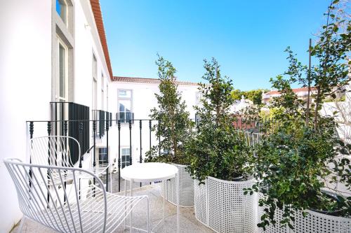 a balcony with a white table and potted plants at MouraSuites Hotel in Évora