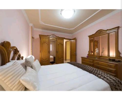 a bedroom with a large white bed and a dresser at PRECIOSO y AMPLIO apartamento a 2 minutos de la Playa in Arinaga